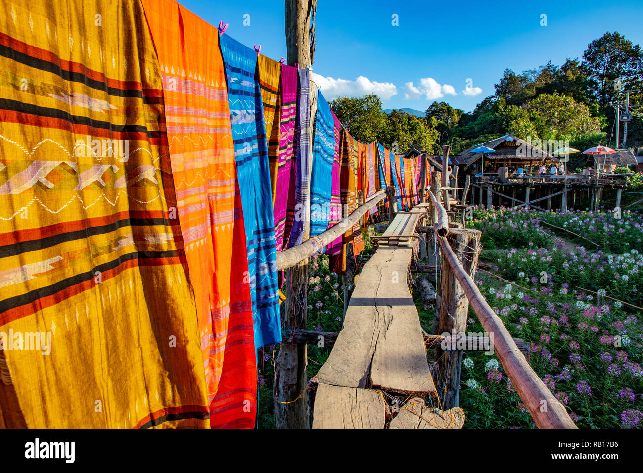 Thailändische kulturelle Baumwollgewebe Hängen entlang Holzbrücke überqueren Blume Bereich. Stockfoto