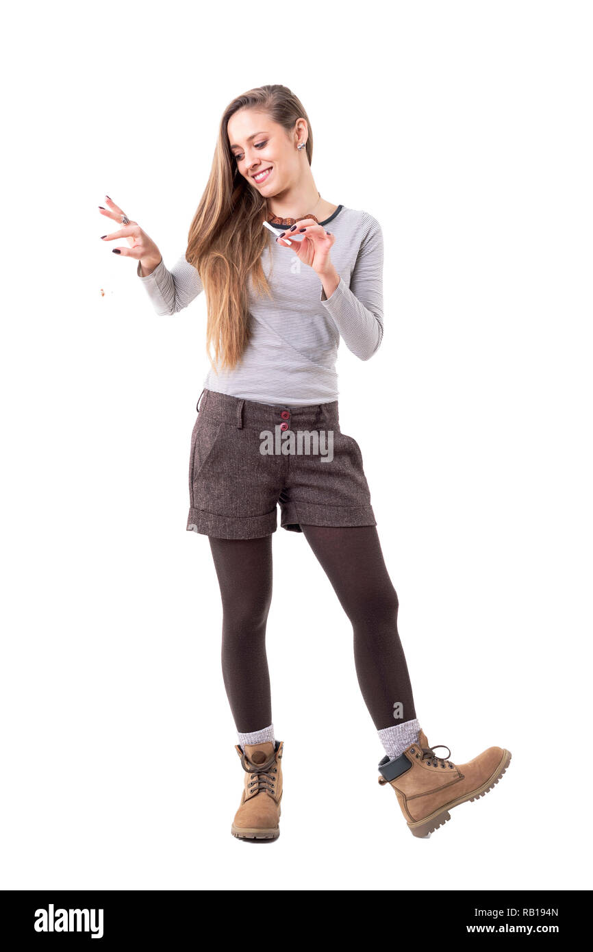 Authentische offene lange Haare hipster girl Tropfen Tabak bleibt rolling Zigarette. Voller Körper auf weißem Hintergrund. Stockfoto