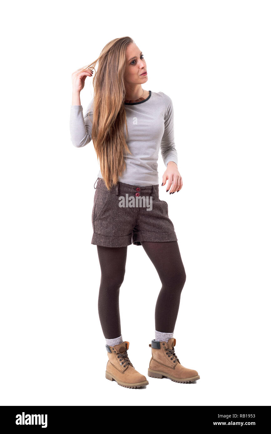 Entspannt candid unposed stilvolle Hipster girl Holding Haar und weg schauen. Voller Körper auf weißem Hintergrund. Stockfoto