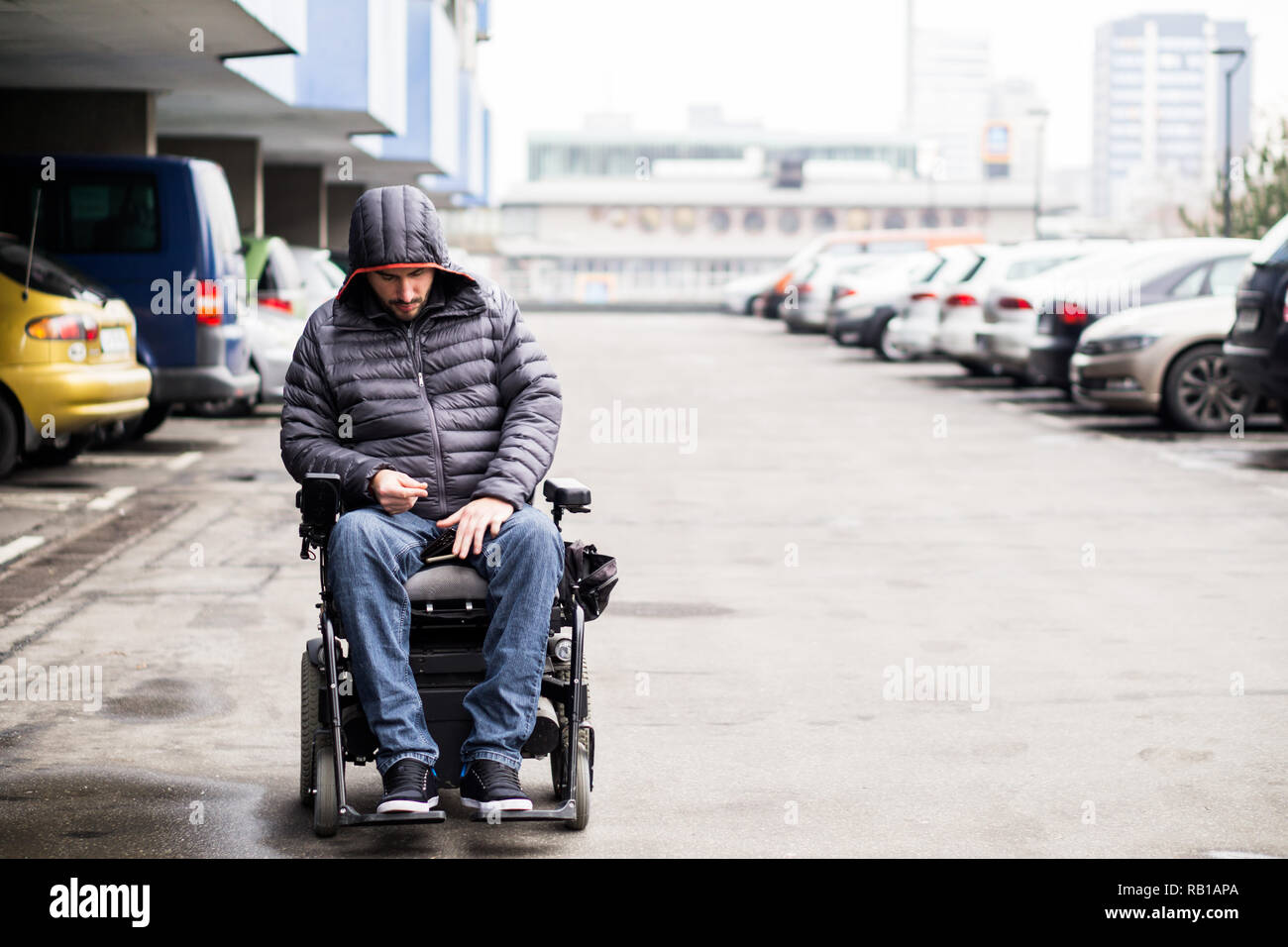 Junge, Erwachsene Rollstuhlfahrer auf einem Parkplatz mit Platz kopieren Stockfoto