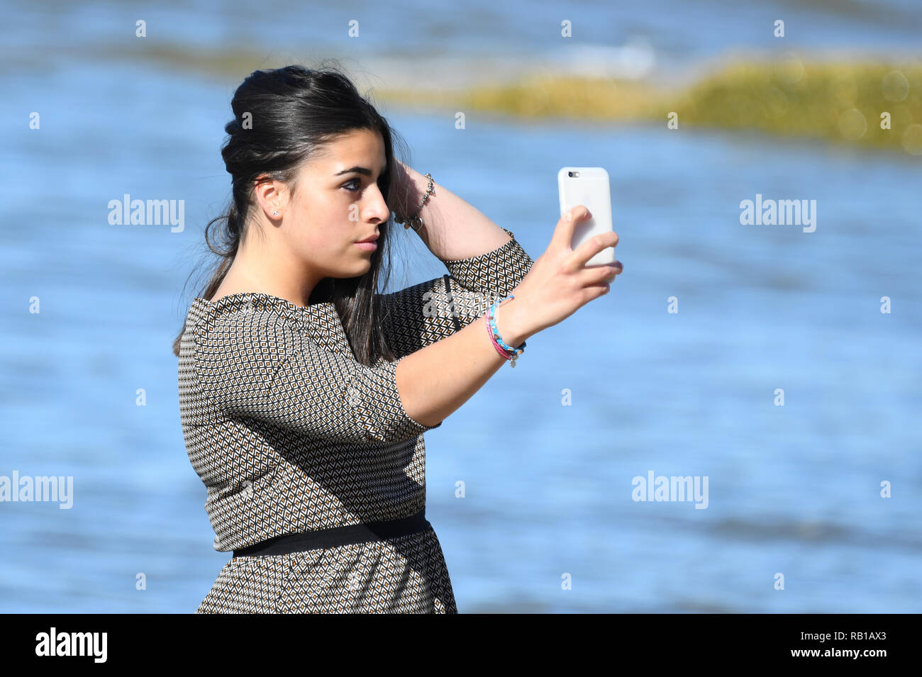 Junge Frau, Teenager oder frühen 20s, wobei selfie Foto auf einem Smartphone auf einem Strand. Stockfoto