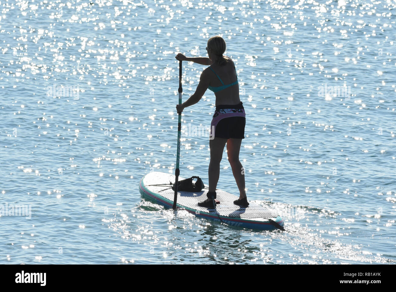 Single paddle boarder Silhouette auf das Meer. Paddleboarder Paddle Boarding. Stockfoto