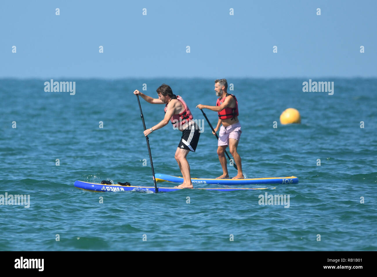Ein Paar der Leute mit paddleboards im Juli 2018 Hitzewelle in England, Großbritannien. Paddleboards. Paddle Boards. Paddle Board. Paddleboarding. Stockfoto