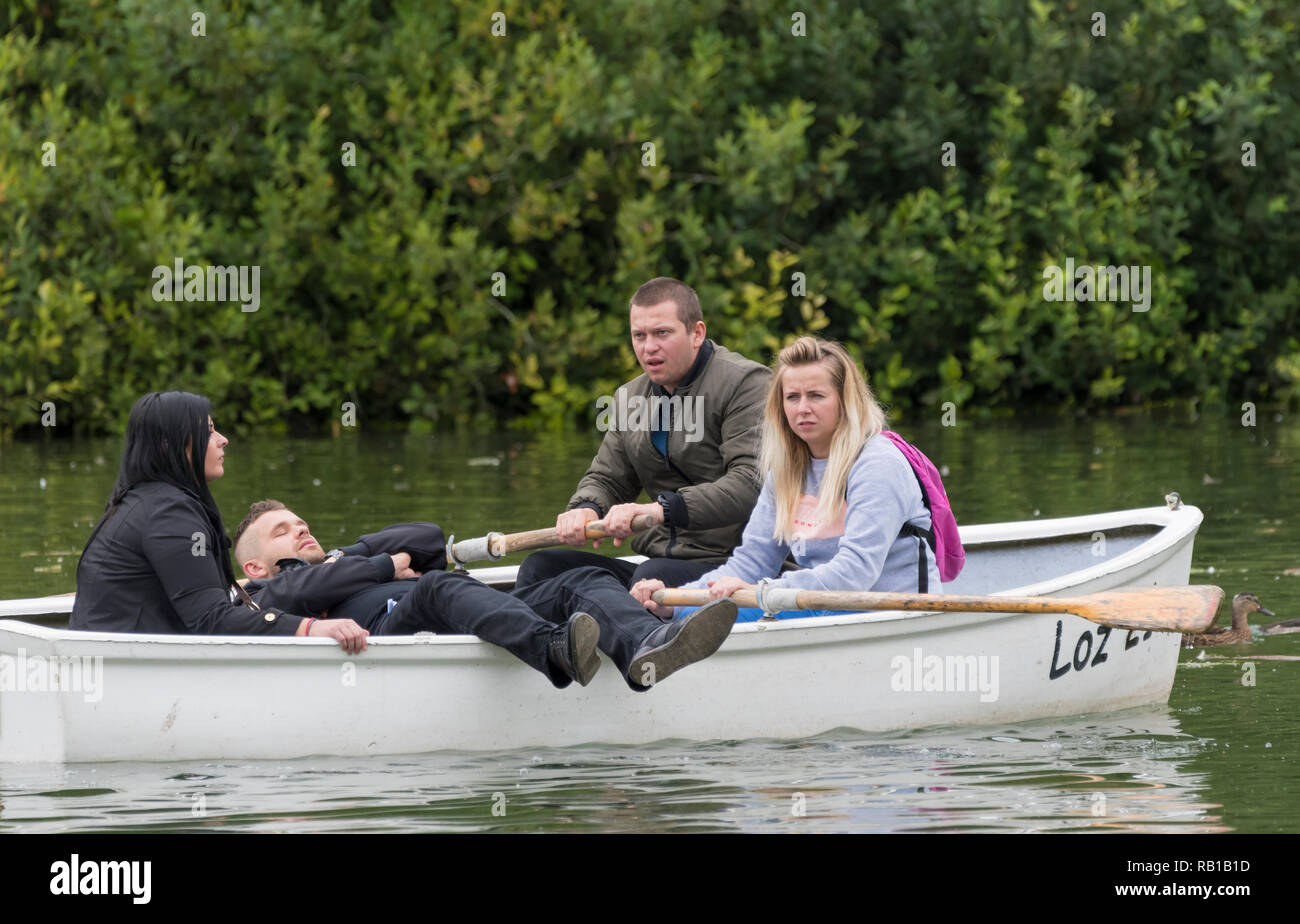 Gruppe von jungen Leuten in einem Boot auf einem See zum Bootfahren in Swanbourne See, Arundel, West Sussex, England, UK. Stockfoto