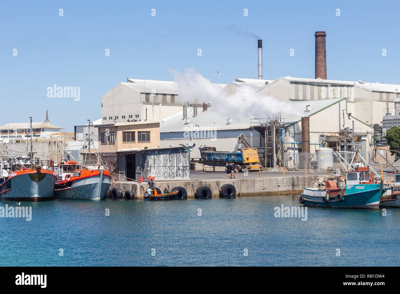 Lambert's Bay, Südafrika - Dezember 20, 2018: Bild von Lambert's Bay Hafen mit Fischkuttern und fischverarbeitende Fabrik mit Schornsteinen in der Ba Stockfoto