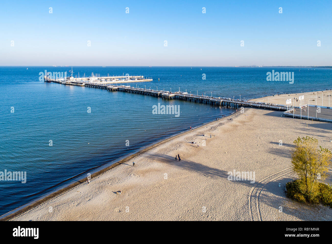 Hölzerne Seebrücke mit Hafen, Pirate touristische Schiff, Marina mit Yachten und Strand von Sopot Resort in der Nähe von Danzig in Polen im Abendlicht. Luftaufnahme Stockfoto
