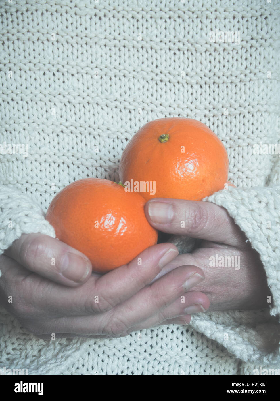 Frau mit Tangerine in ihre Hände Stockfoto