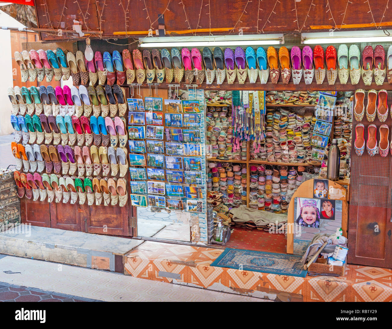 1001 Schuhe und andere Waren auf Verkauf in einem Stall in einem traditionellen Souk in der Altstadt von Dubai, VAE. Stockfoto