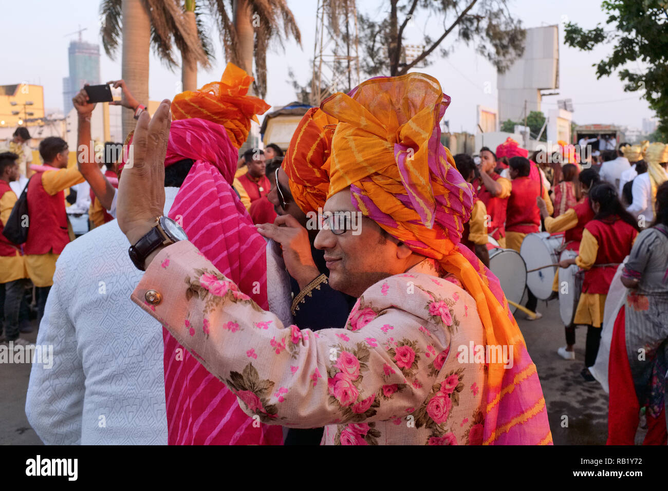 Eine festlich gekleidete Gäste Bei einer Hochzeit in den Marwari Gemeinschaft in Mumbai, Indien, ruft zu einem Freund Stockfoto