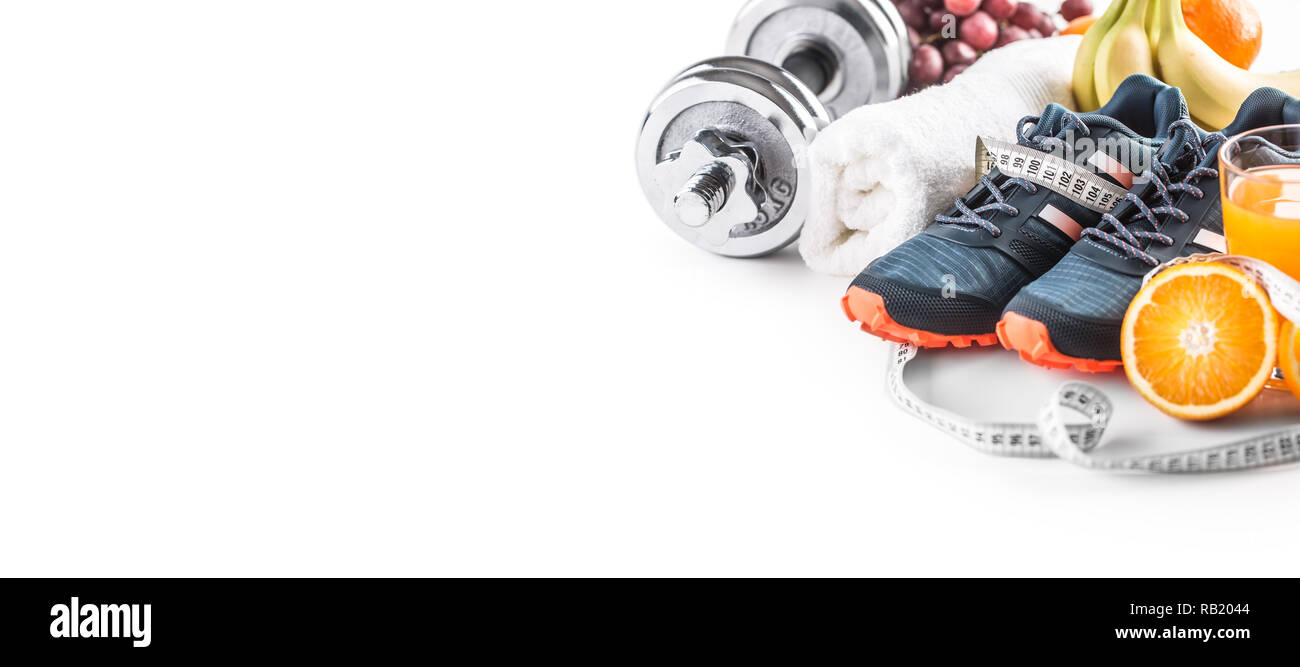 Sport Schuhe Kurzhanteln frisches Obst Maßband und Multivitaminsaft auf weißem Hintergrund. Gesunder Sport und Diät Konzept. Stockfoto