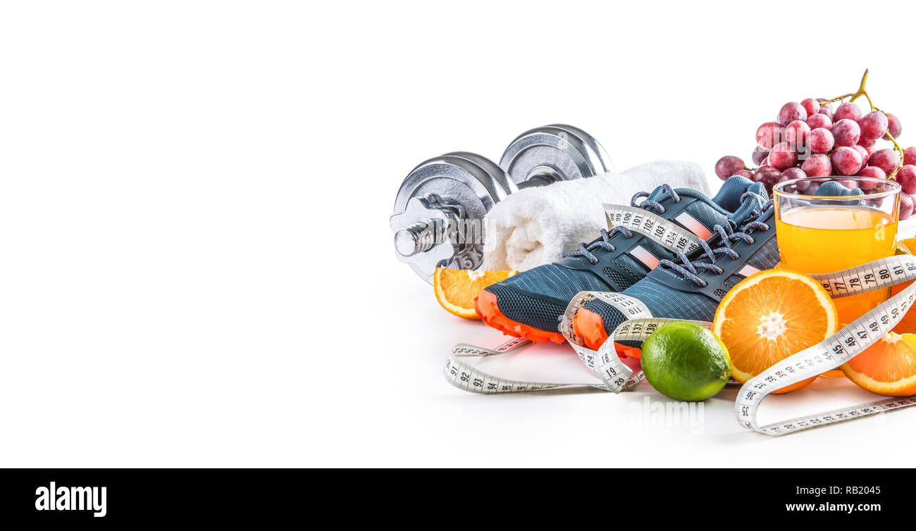 Sport Schuhe Kurzhanteln frisches Obst Maßband und Multivitaminsaft auf weißem Hintergrund. Gesunder Sport und Diät Konzept. Stockfoto