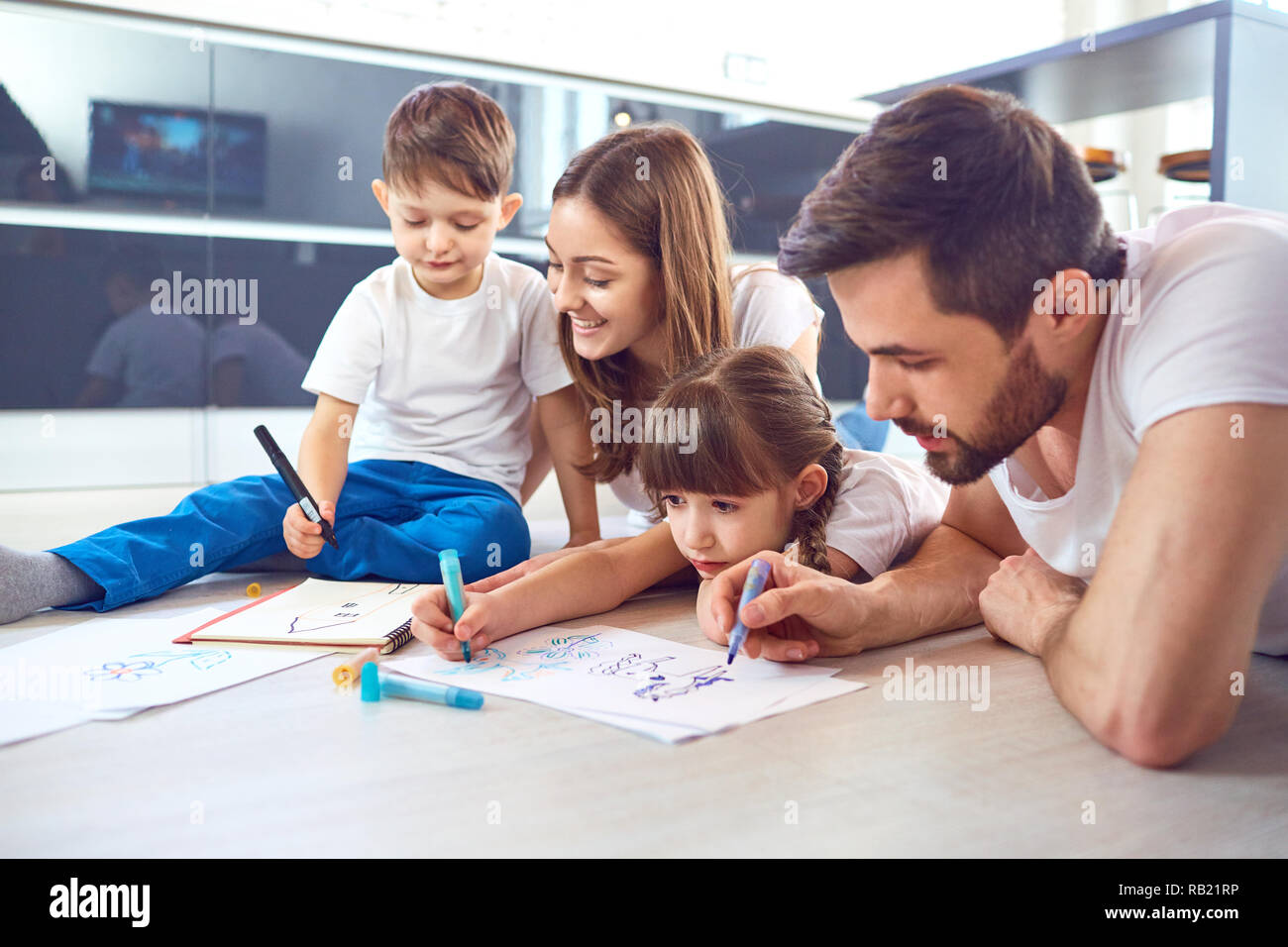 Eine Familie zieht auf dem Papier liegen auf ihre freie Zeit auf dem Boden. Stockfoto