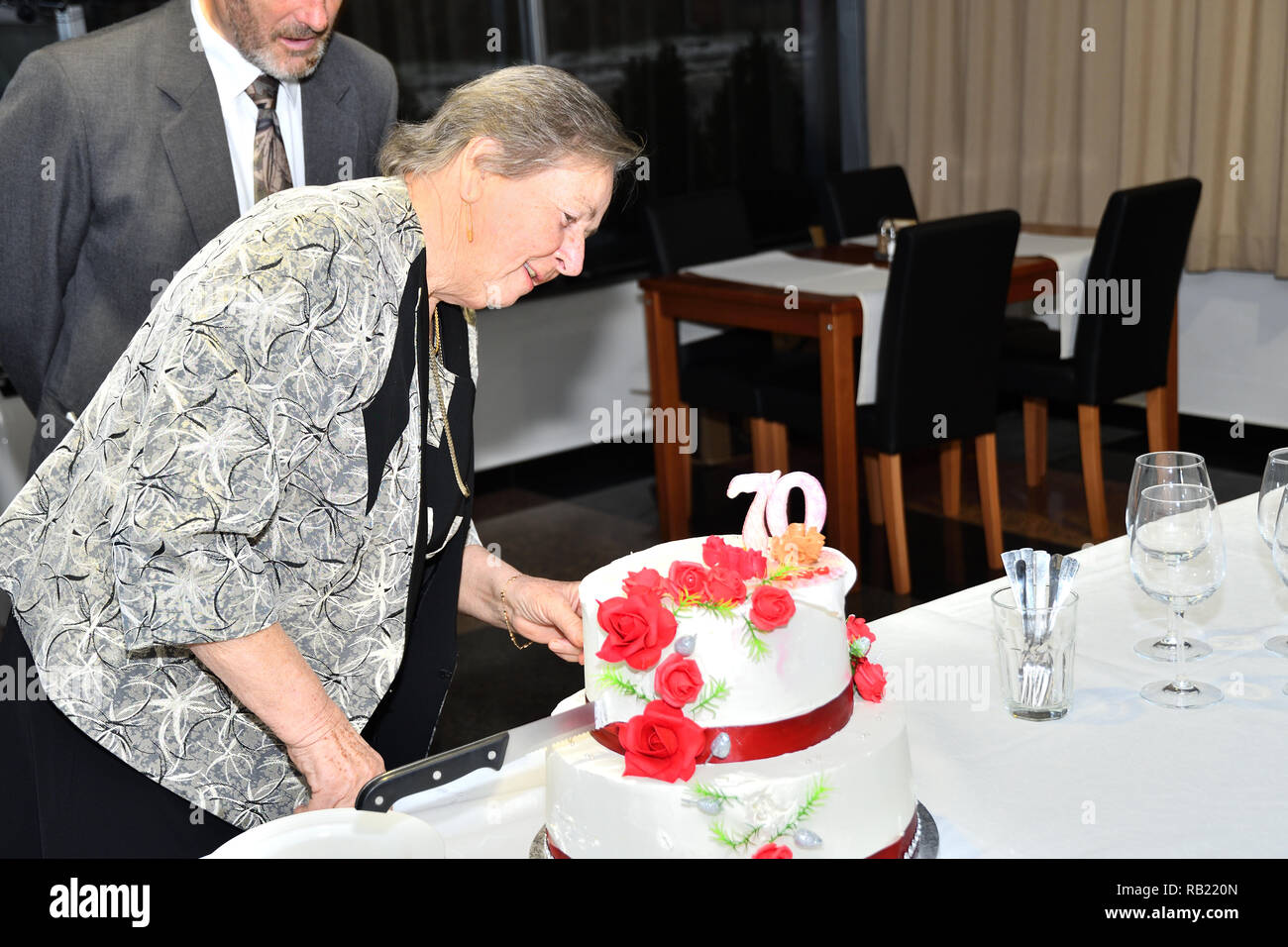 Familienfeier und Schneiden von Kuchen für den 70. Jahrestag Stockfoto