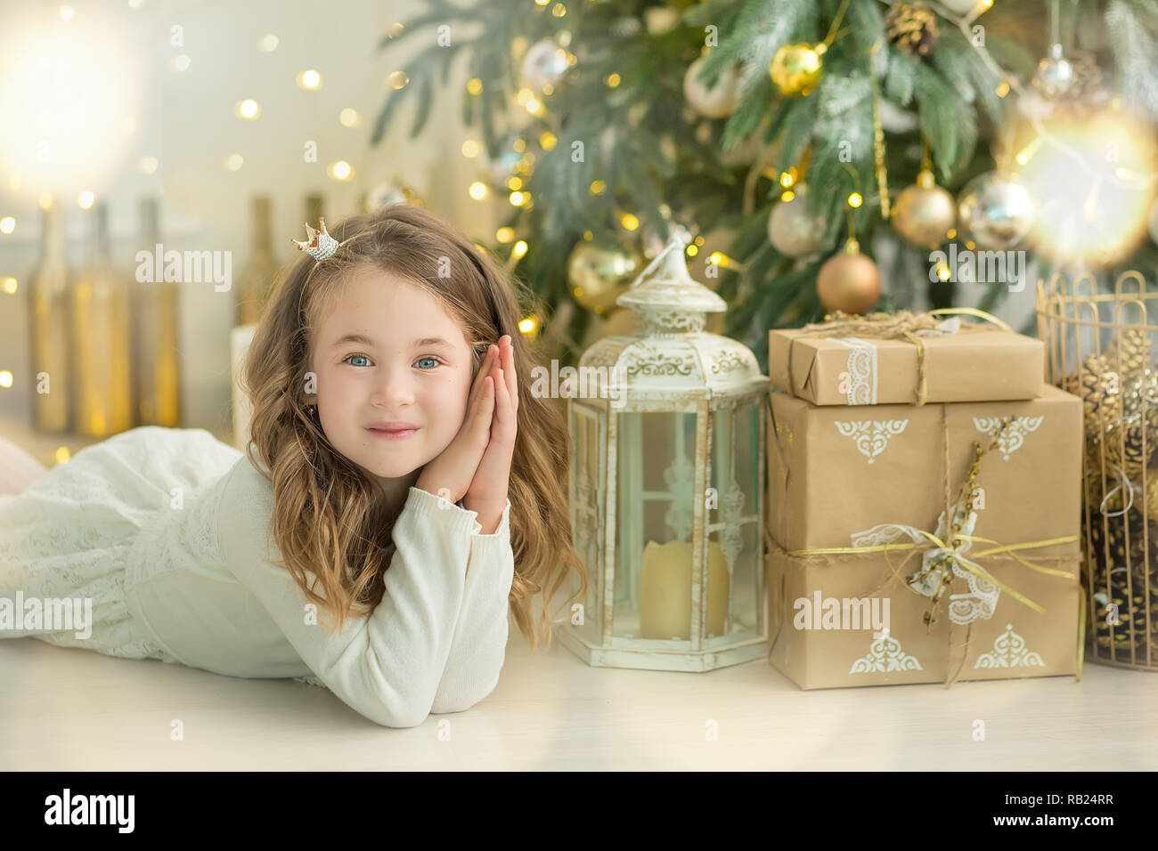 Familie am Weihnachtsabend am Kamin. Kinder öffnen Geschenke. Kinder unter Weihnachtsbaum mit Geschenkboxen. Eingerichtetes Wohnzimmer mit Traditiona Stockfoto