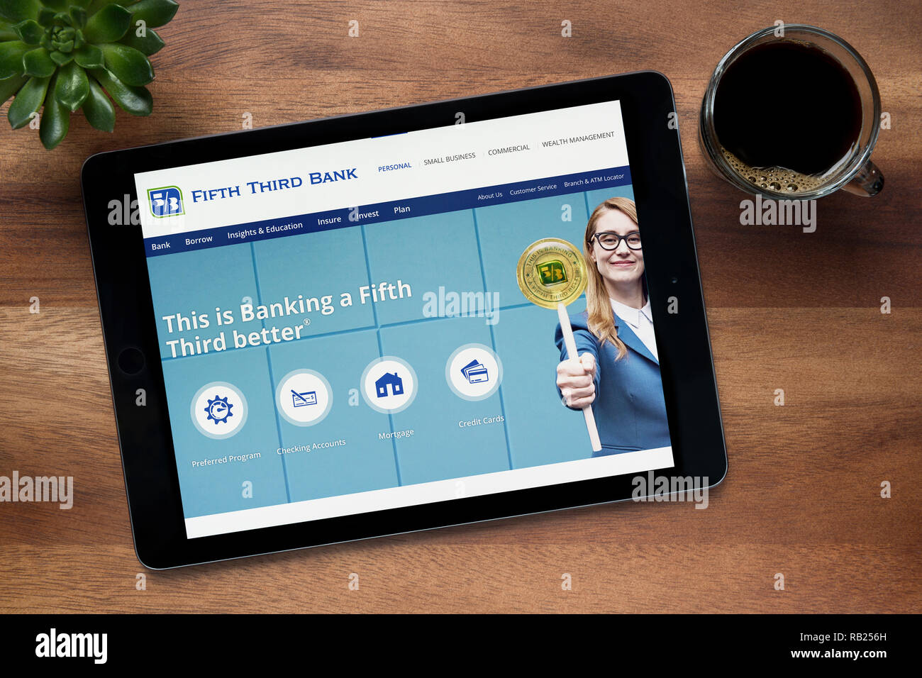 Die Website von Fifth Third Bank ist auf einem iPad Tablet gesehen, auf einer hölzernen Tisch zusammen mit einem Espresso und einem Haus Anlage (nur redaktionelle Nutzung). Stockfoto Die Website von Fifth Third Bank ist auf einem iPad Tablet gesehen, auf einer hölzernen Tisch zusammen mit einem Espresso und einem Haus Anlage (nur redaktionelle Nutzung). Stockfoto