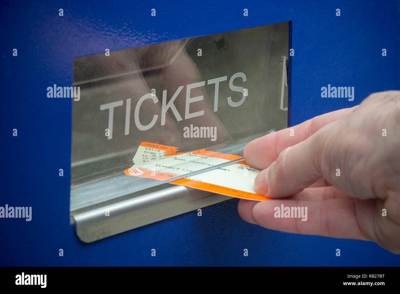 Ein Mann sammelt eine Fahrkarte von einem Ticket Automaten an einem britischen Bahnhof entfernt. Stockfoto