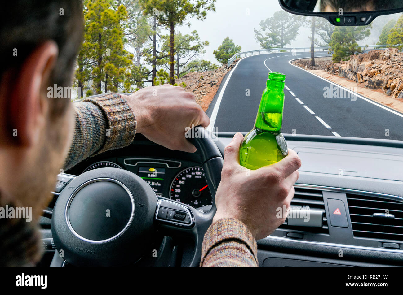 Betrunkene junge Mann, der ein Auto fährt auf der Straße mit einer Flasche  Bier. Nicht trinken und fahren. Betrunken Fahren unter dem Einfluß. Fahren  während berauschte Stockfotografie - Alamy