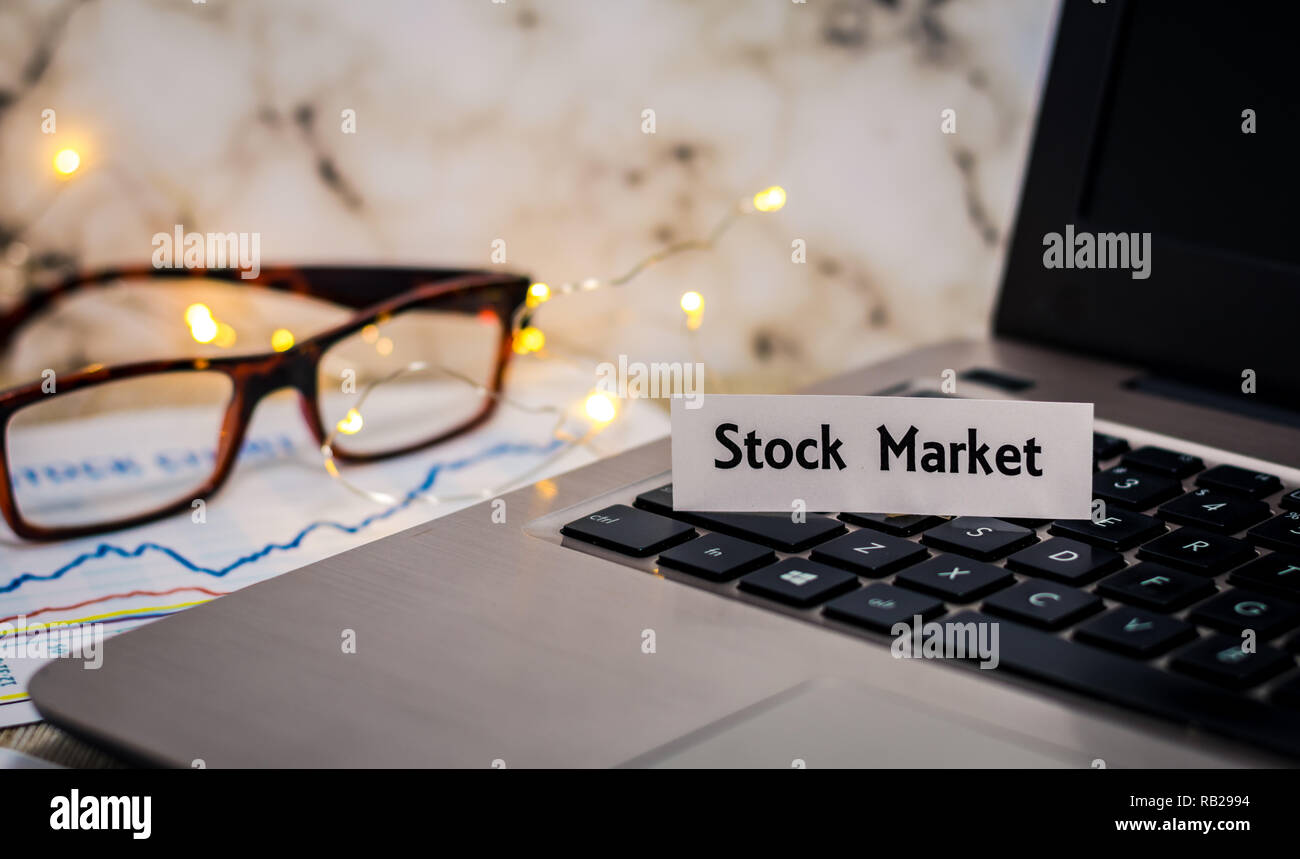 Börse still life Konzept mit Laptop, Aktienkurs, flacher DOF Stockfoto