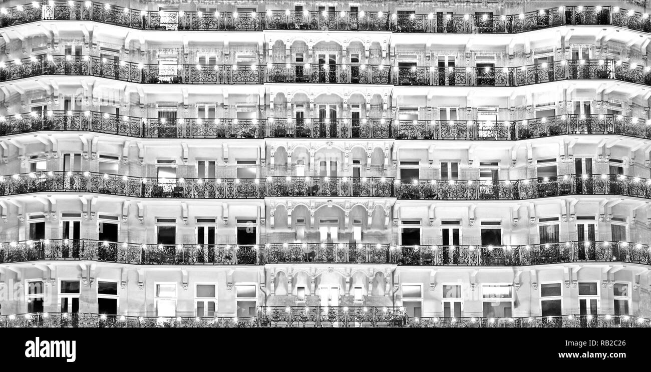 Der sich wiederholende Muster der Vorderseite eines weißen Grand Regency Hotel rosa Gebäude mit kunstvollen Formen, schwarzen schmiedeeisernen Balkonen und Fenstern, die balconi Stockfoto