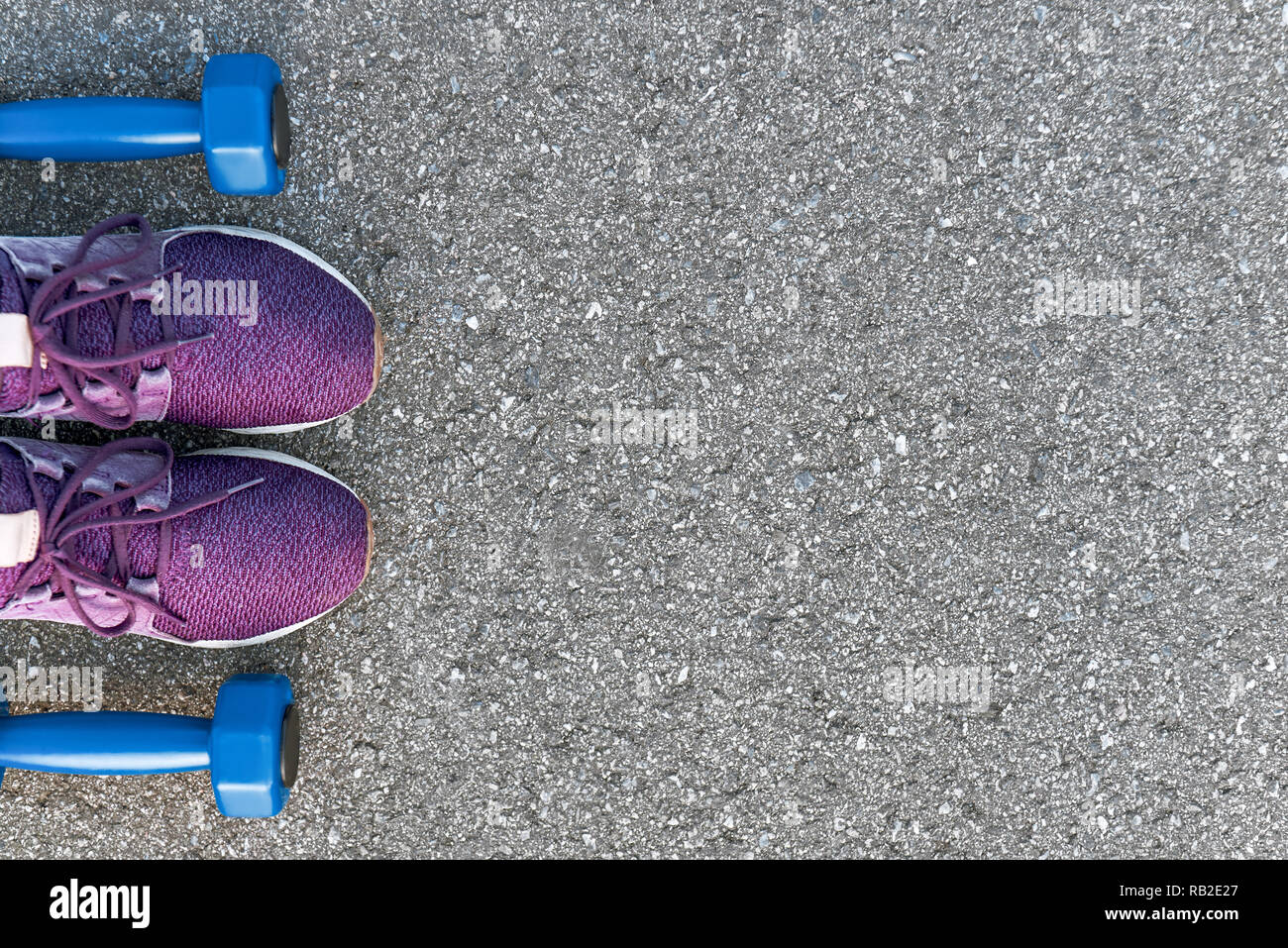 Bereit zum Training. Foto von dumpbells und lila Turnschuhe am Asphalt Hintergrund abgeschnitten. Sport motivation Stockfoto