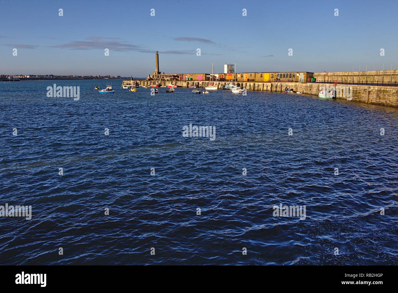 Blick über das Wasser bis zum Hafen Arm Pier bei Flut an einem sonnigen Tag Stockfoto