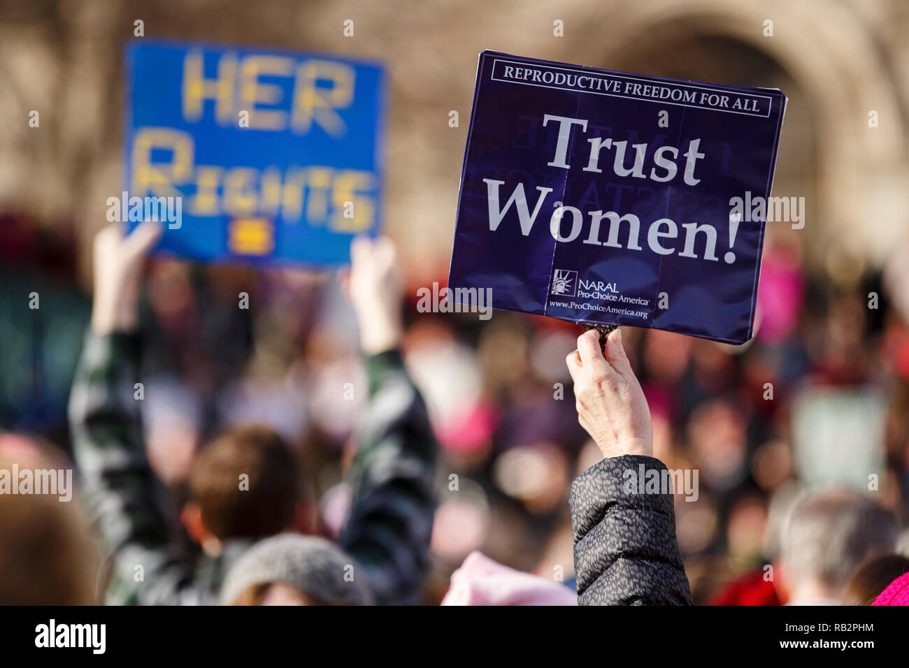 Ein Teilnehmer besitzt einen "Vertrauen Frauen'-Schild über einem großen Publikum während der 2018 Frauen März Rallye am Samstag, den 20. Januar. Stockfoto