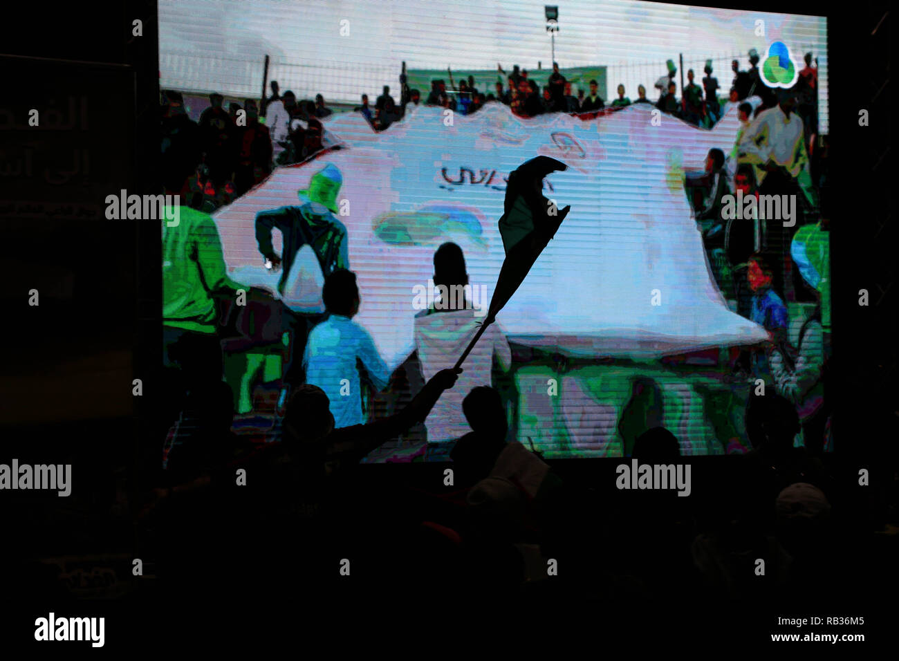 Gaza, Palästina. 6. Januar, 2019. Silhouetten von Fans, die das Spiel beobachten. palästinensischen Fans beobachten Sie die 2019 AFC Asian Cup Gruppe B Fußball zwischen Palästina und Syrien auf einem großen Bildschirm, in Gaza Stadt. Das Spiel endete mit einem 0:0-Unentschieden. Credit: Ahmad Hasaballah/SOPA Images/ZUMA Draht/Alamy leben Nachrichten Stockfoto