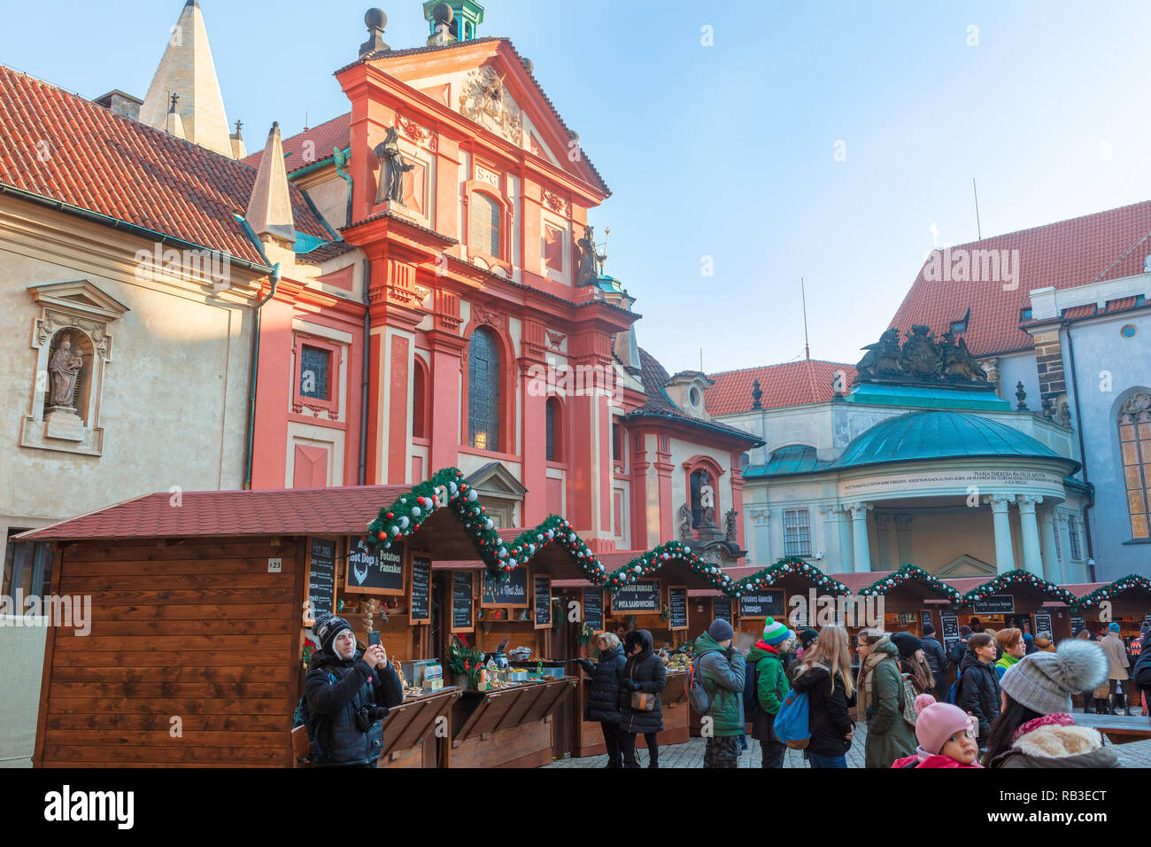 Touristen, die in Der beliebte Weihnachtsmarkt auf der Prager Burg in der Nähe von St George's Basilica. Stockfoto