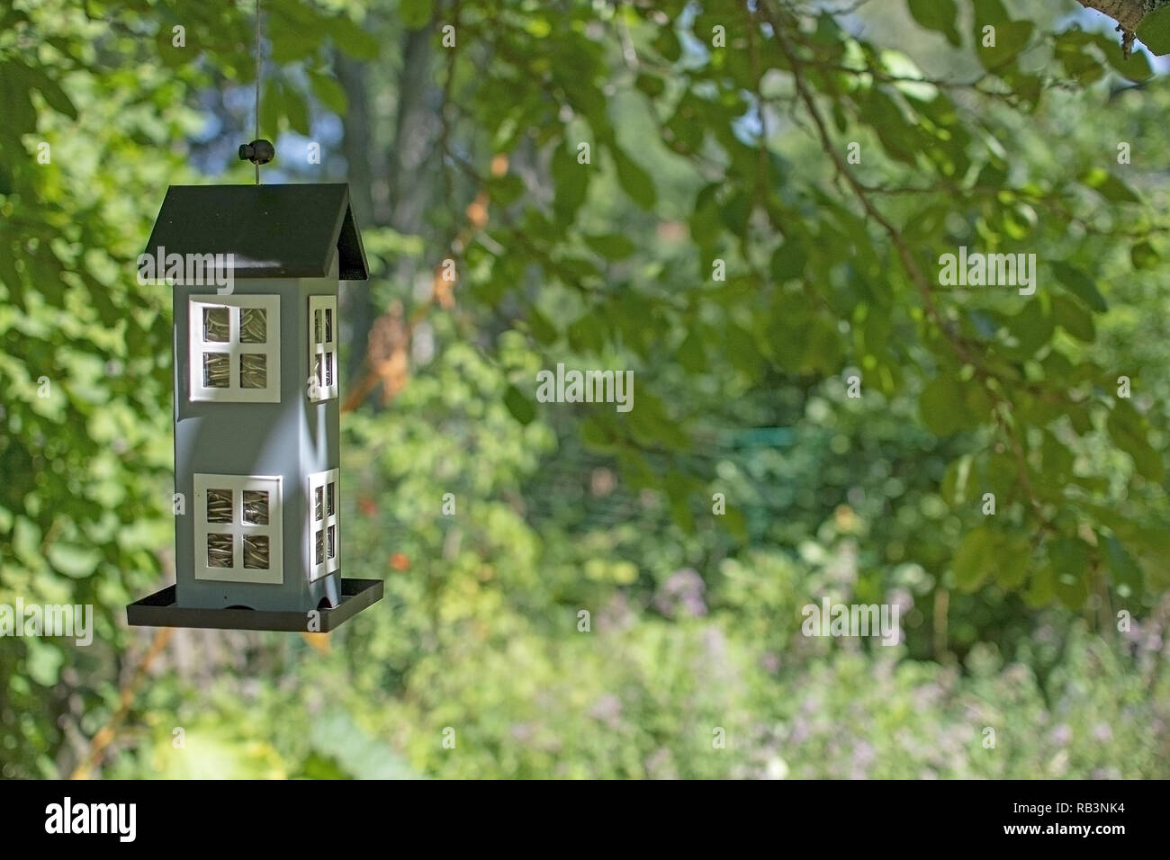 Niedlichen Vogelhäuschen hängend im grünen Garten Konzept für den Kauf oder Verkauf von Immobilien neues Zuhause oder eine Familie Stockfoto