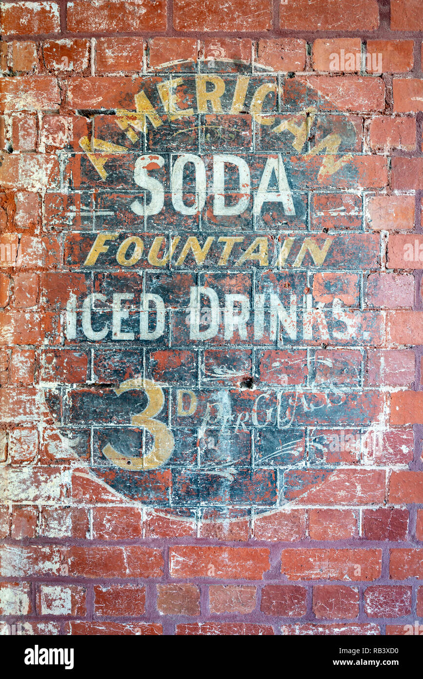 Ein verwittertes und verblasste amerikanische Soda Fountain Zeichen gefunden an der Seite eines australischen Bürogebäude Stockfoto