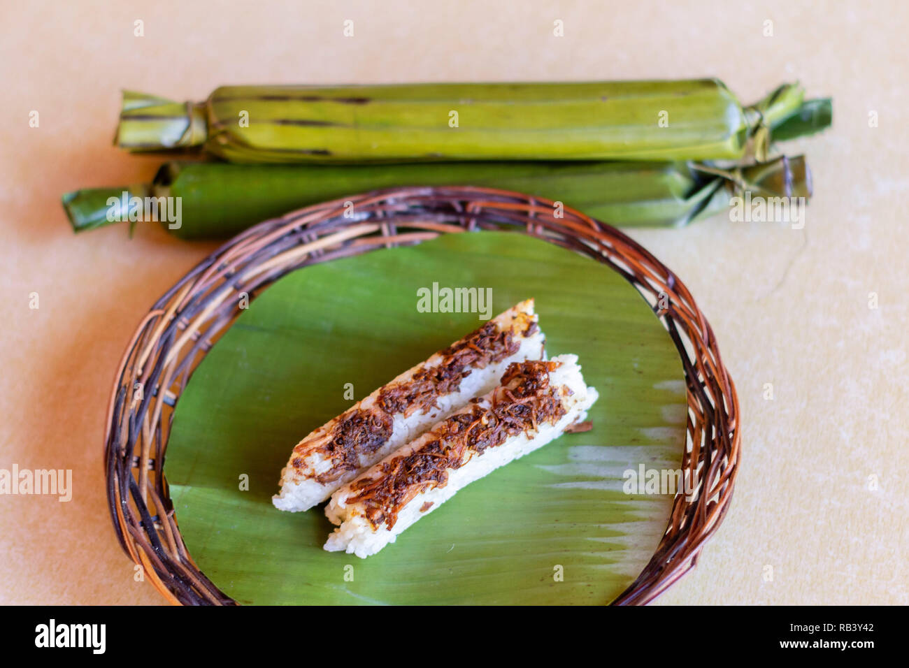 Ein lokales Essen von Cotabato City aus gedämpftem Reis mit Fleisch und in Bananenblätter gewickelt Stockfoto