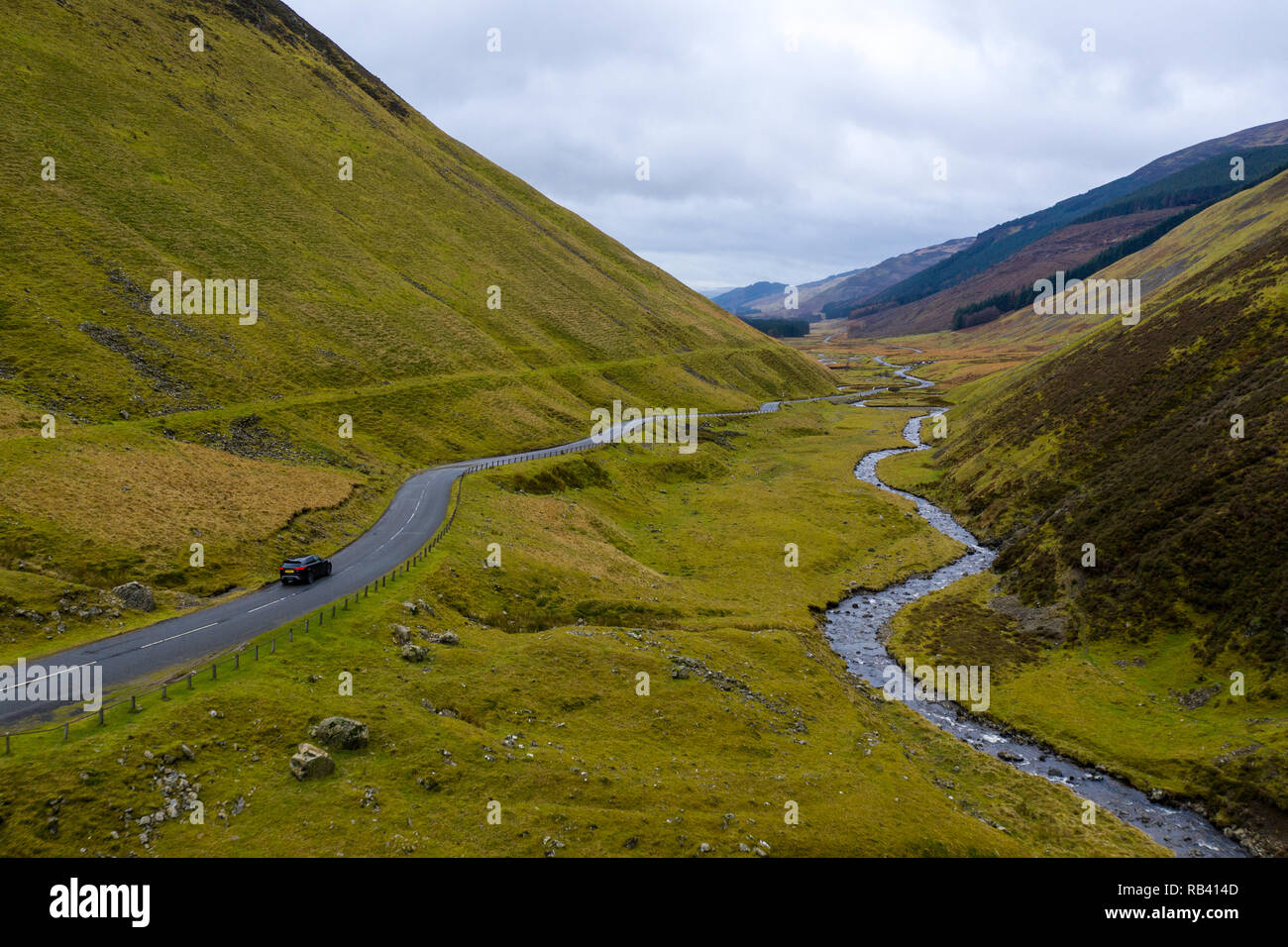 SUV auf windigen Straße in grüne vulkanische Berge der schottischen Highlands Stockfoto