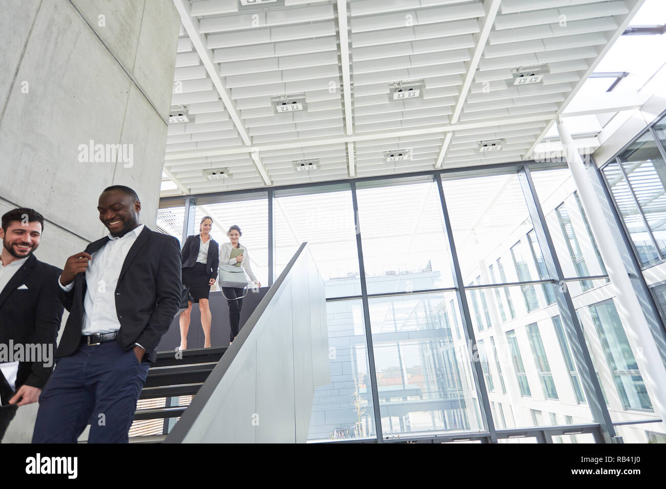 Kollegen auf der Treppe im Gespräch in der modernen Unternehmenszentrale Stockfoto