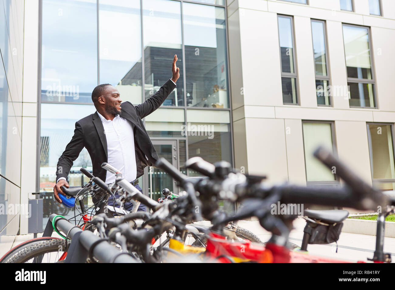 Klimafreundliche business Mann mit Fahrrad als Pendler vor dem Büro Stockfoto