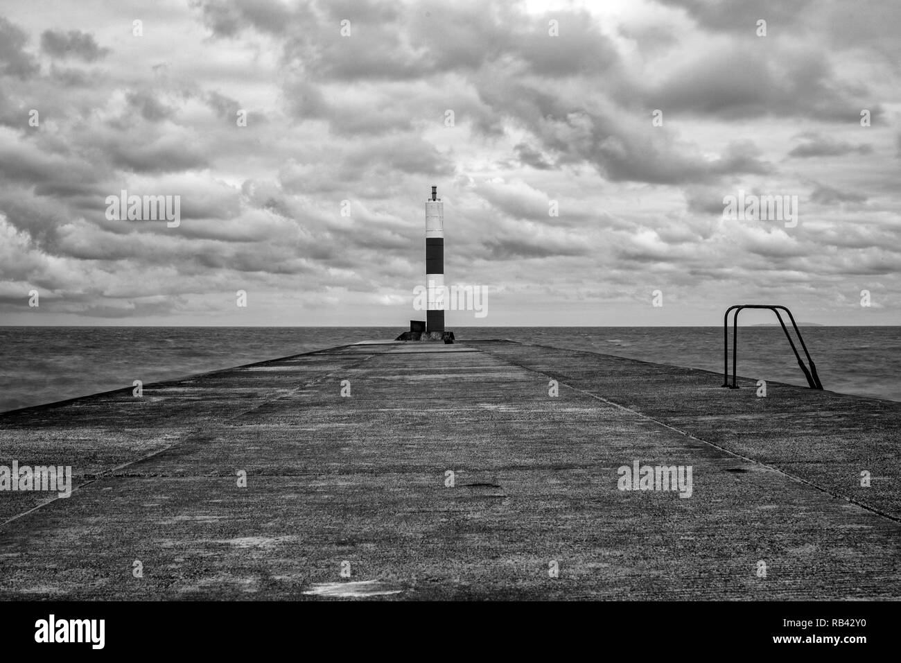 Stein Jetty in Schwarzweiß mit Leuchtfeuer in Aberystwyth Ceredigion Wales UK Stockfoto