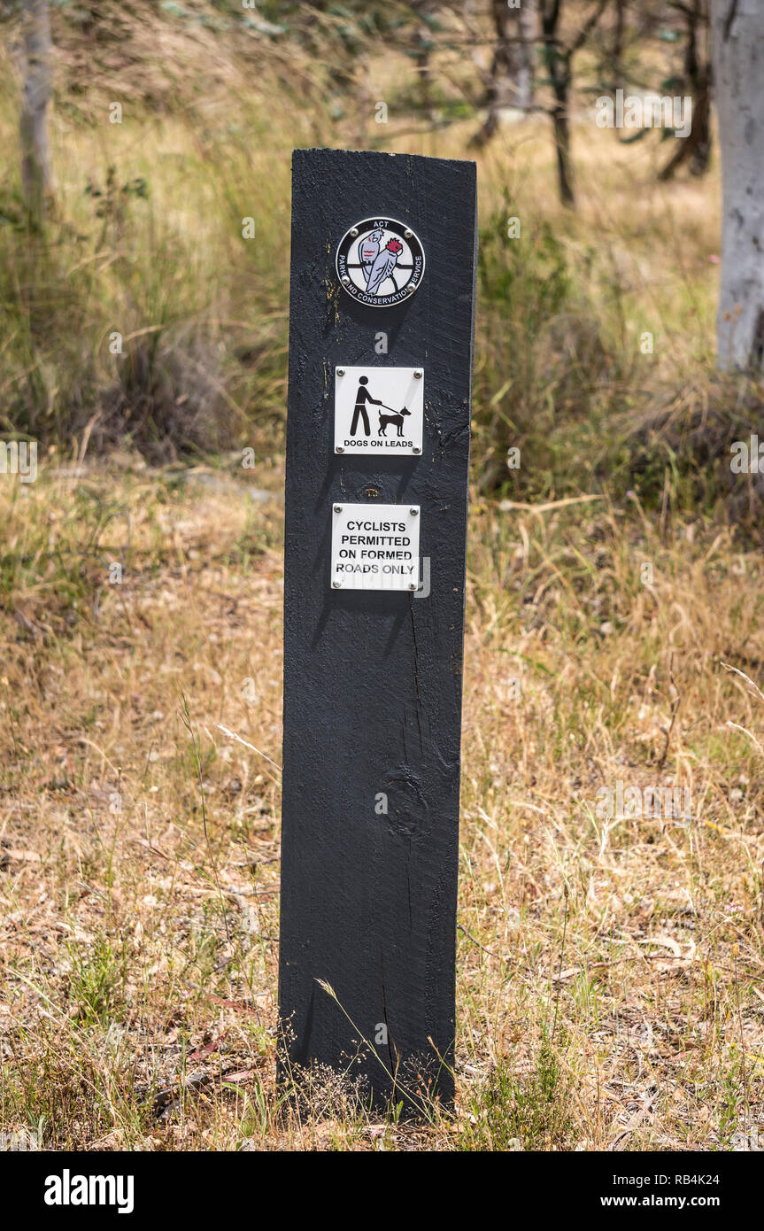 Zeichen in der Mount Ainslie Nature Reserve in der Nähe von Canberra im Australian Capital Territory unter Angabe der Regeln für wenige Hunde und Radfahrer. Stockfoto