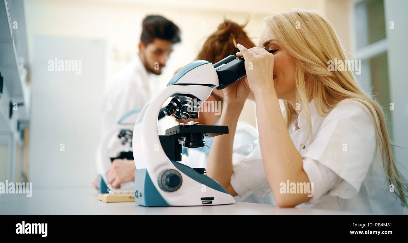 Junge Wissenschaftler durch Mikroskop im Labor auf der Suche Stockfoto
