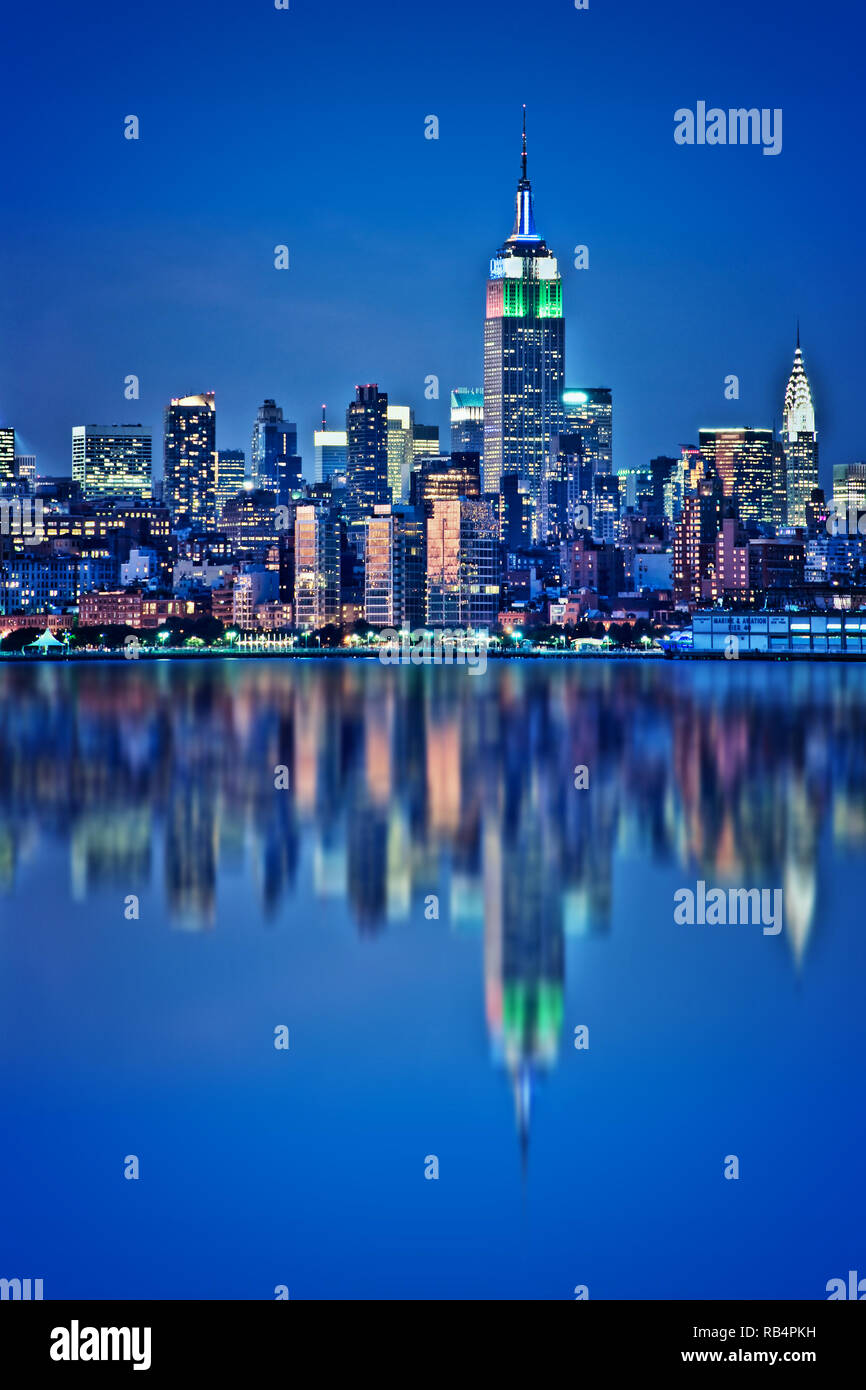 New York Skyline mit Wasser Reflexionen bei Nacht Stockfoto