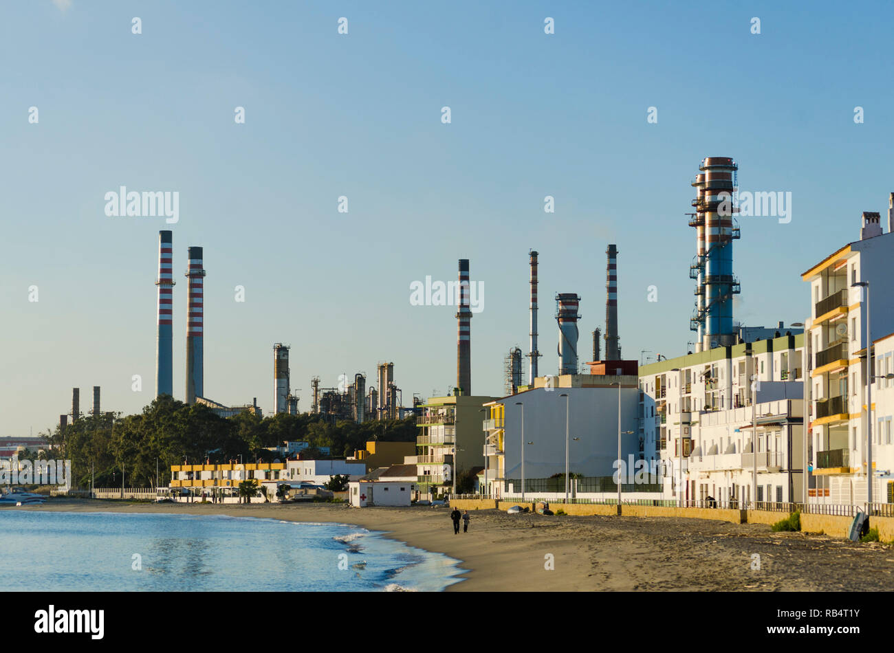 Strand und Wohngegend in San Roque, mit Cepsa Raffinerie Algeciras, hinter, Andalusien, Spanien. Stockfoto