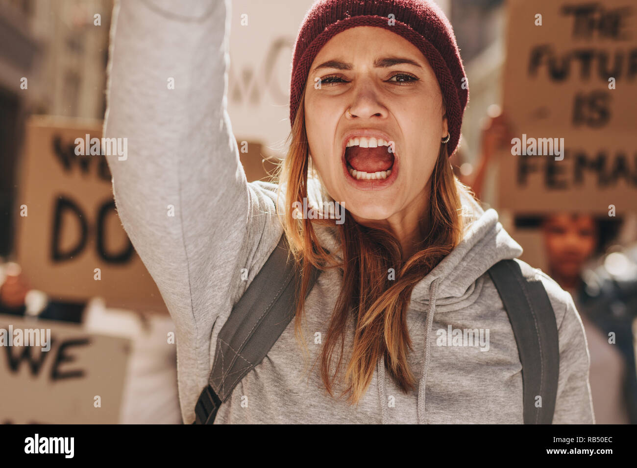 In der Nähe der weiblichen Demonstrantin, die einen Slogan mit einer Gruppe von Menschen im Hintergrund. Frau protestieren für ihre Emanzipation und die Zukunft. Stockfoto