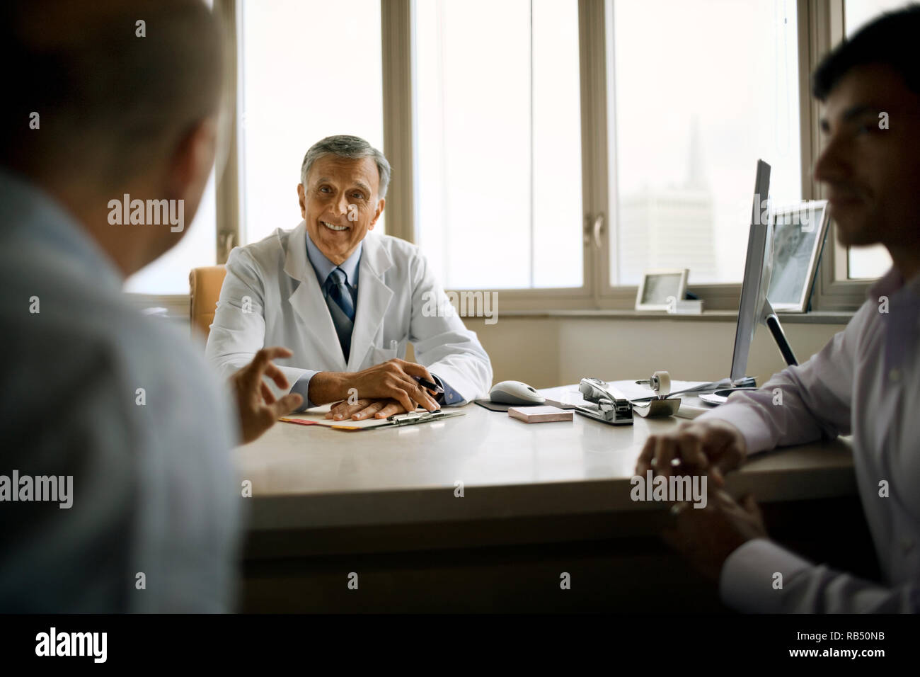 Leitender Arzt Beratung mit Patienten in seinem Büro. Stockfoto