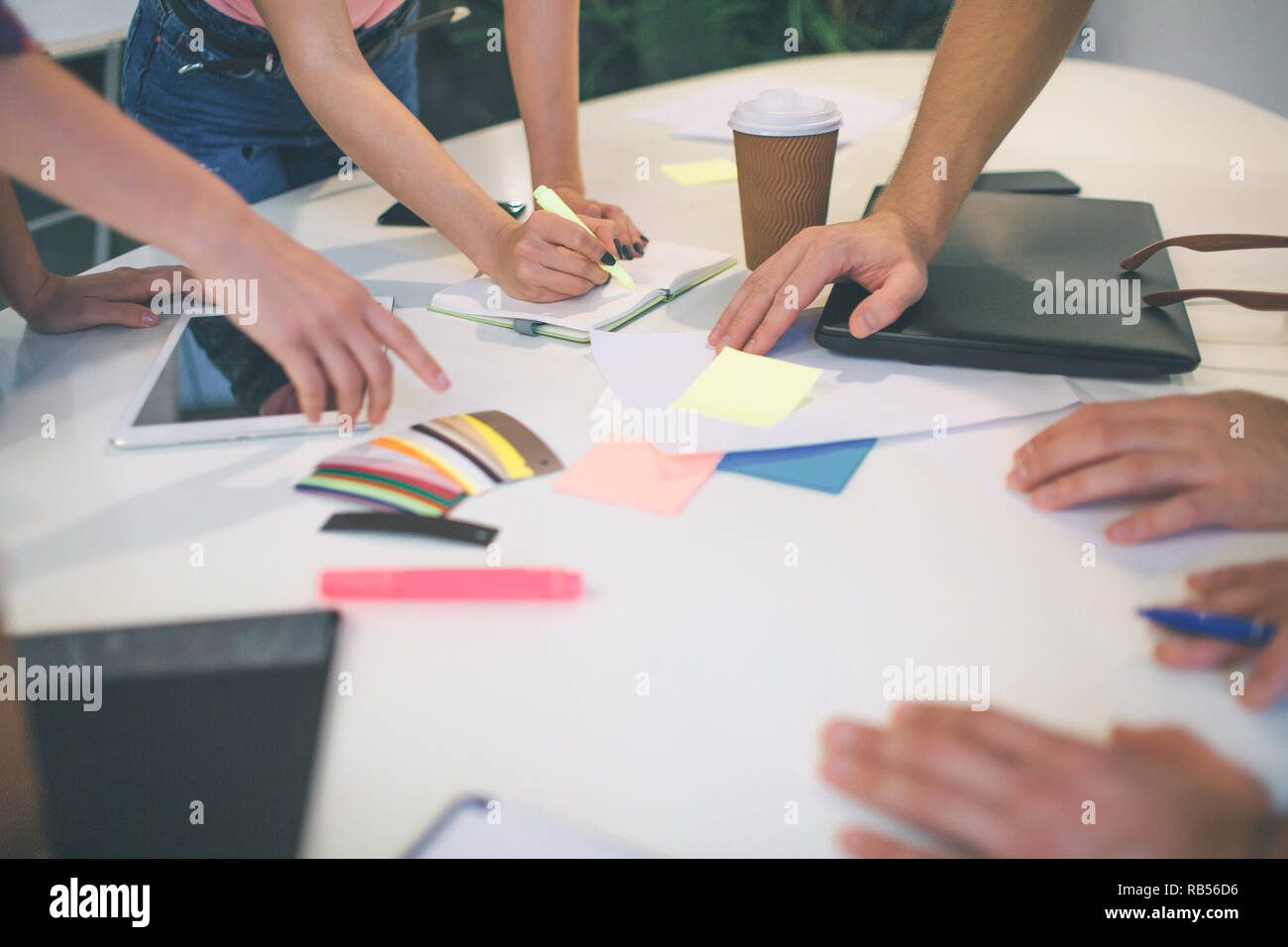 Bild von Männern und Frauen die Hände zeigen auf bunten Aufkleber und ein Stück Papier. Sie arbeiten zusammen. Stockfoto