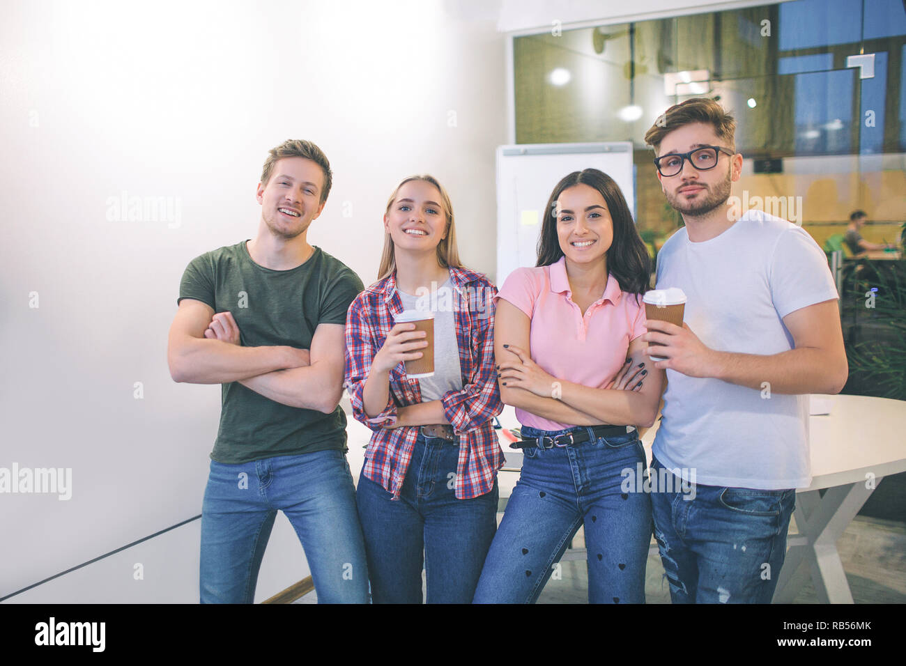 Bild der Junge Männer und Frauen stehen und Posieren vor der Kamera. Sie lächeln. Die Studierenden sind in einem Raum zusammen. Stockfoto