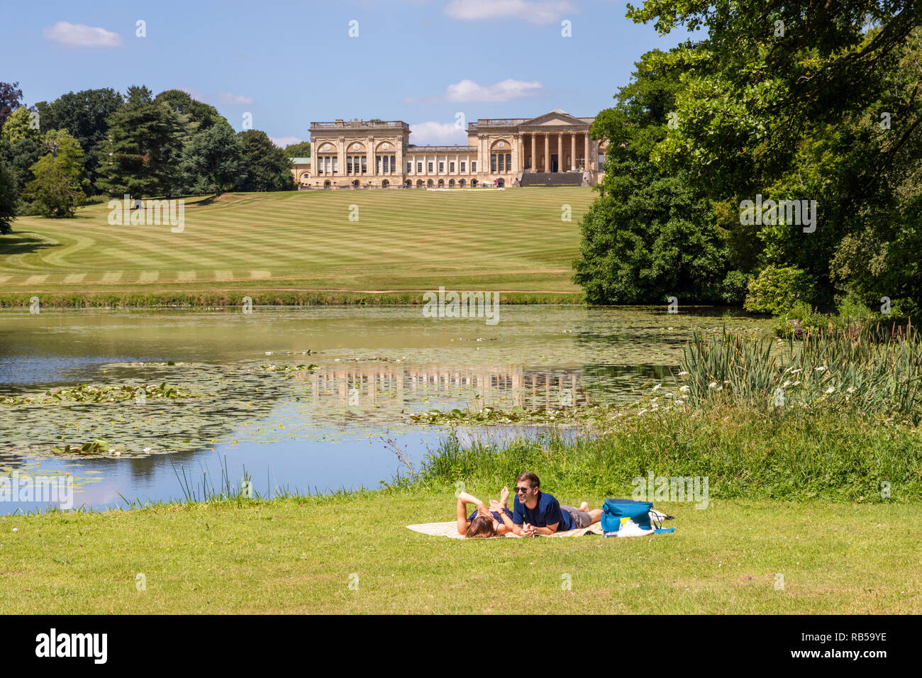 Ein junges Paar beim Picknick am See bei Stowe House Gardens, Buckinghamshire UK Stockfoto
