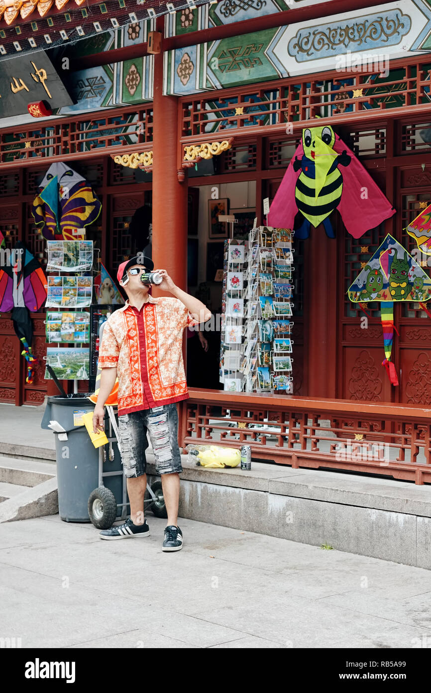 Montreal, Kanada - Juni 2018: Seltsam jungen kanadischen Mann Bier trinken und rauchen Zigarette vor einem Store in Chinatown in Montreal, Kanada. Stockfoto