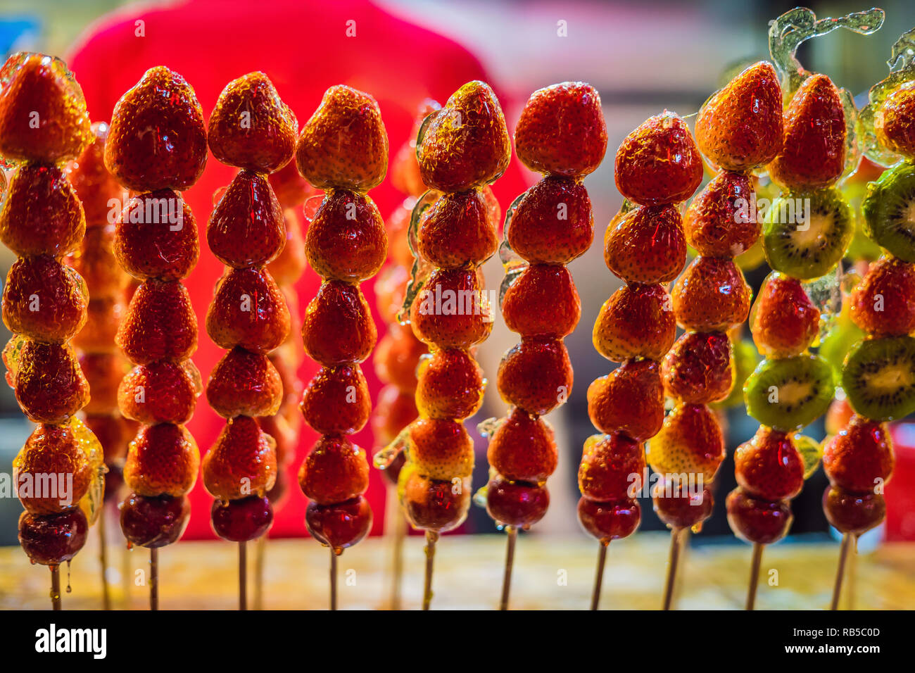 Traditionelle Chinesische Dessert - kandierte Früchte auf einem Holzstab Stockfoto