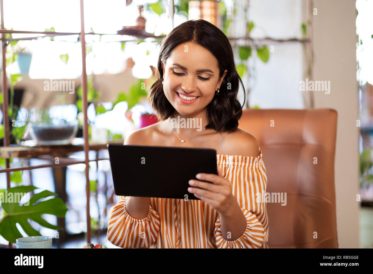 Glückliche Frau mit Tablet-PC im Cafe oder Tee Shop Stockfoto