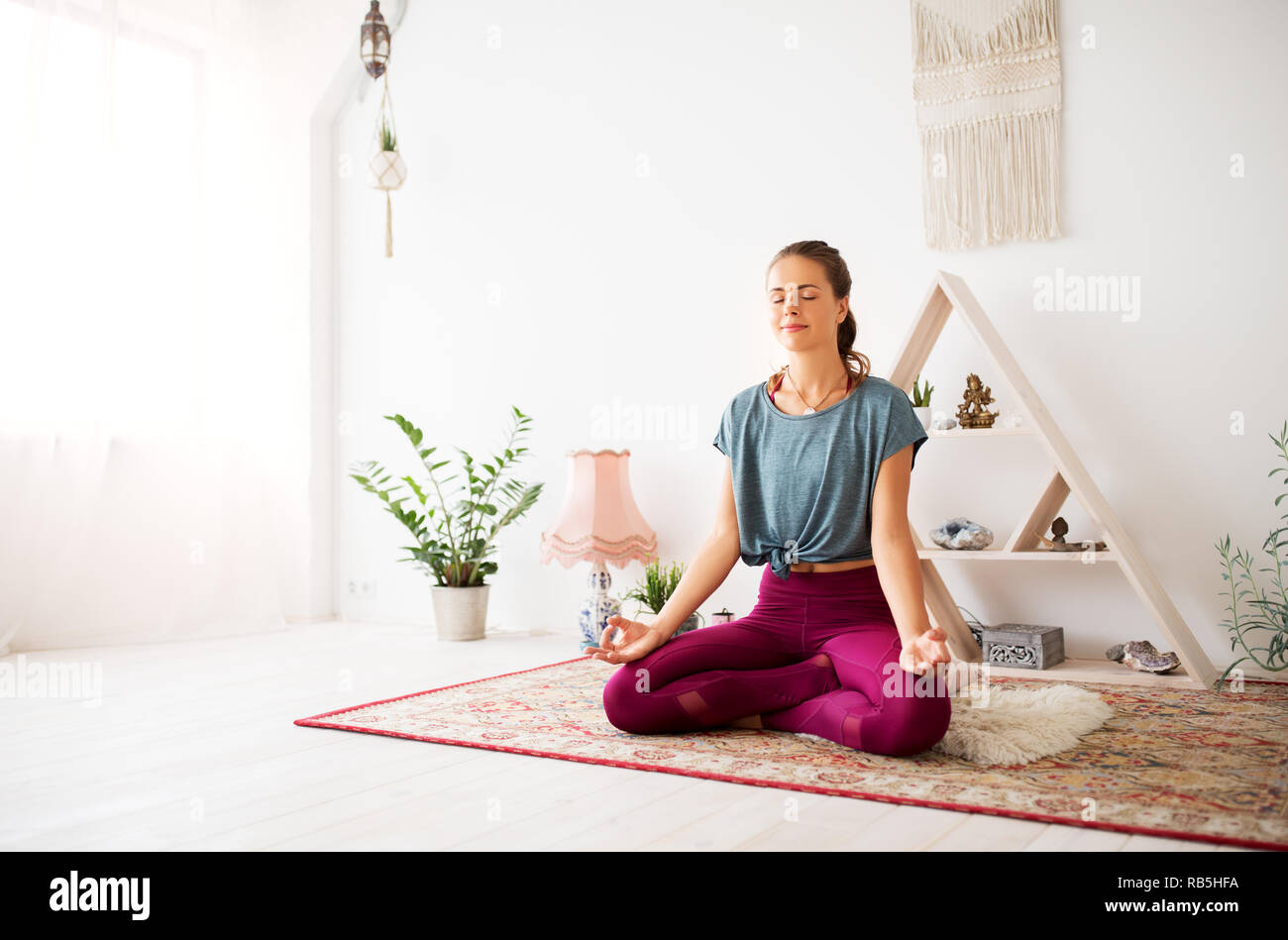 Frau Meditation im Lotussitz auf Yoga Studio Stockfoto