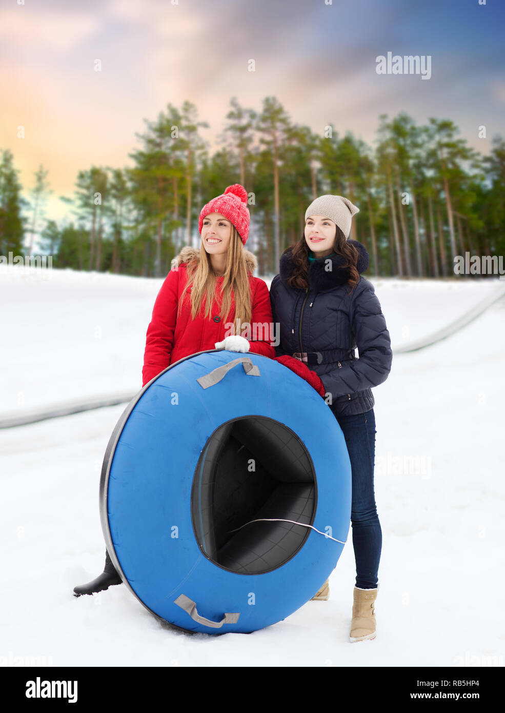 Glückliches Mädchen im Teenageralter mit Snow Tubes im Winter Stockfoto