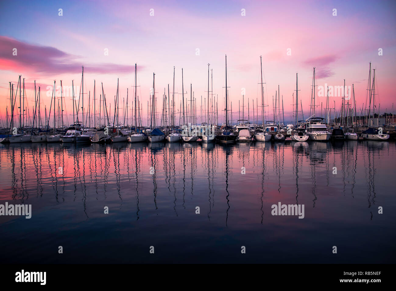Segeln Boote in der Marina mit einer schönen lila Sonnenuntergang verankert. Stockfoto